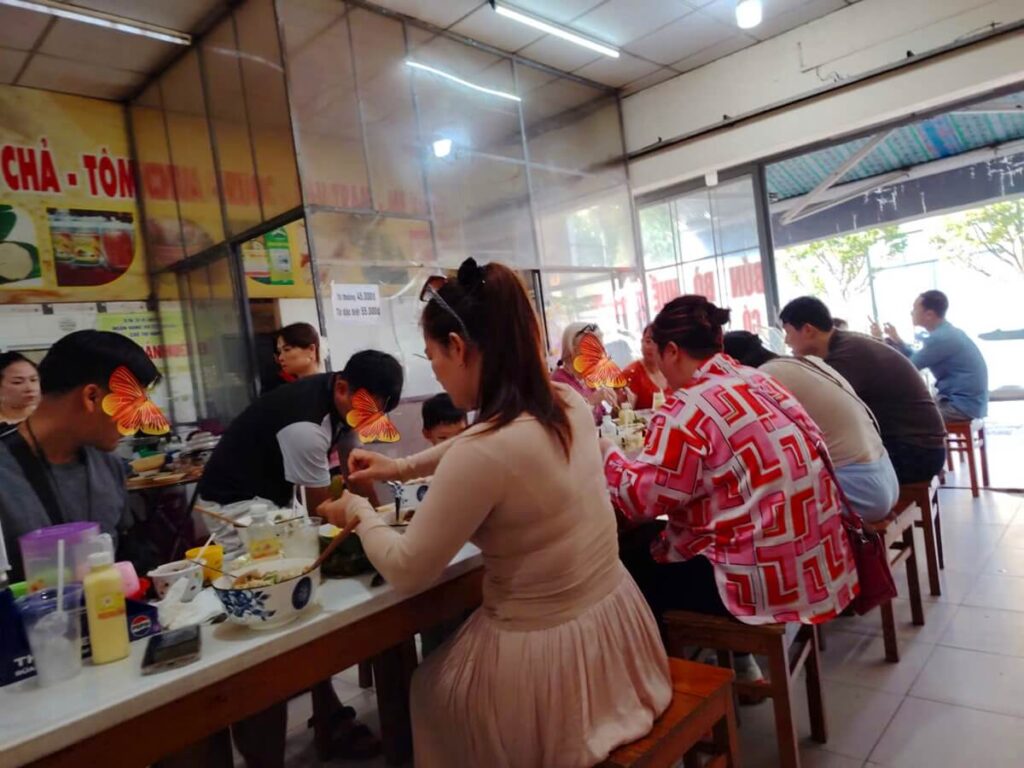 Family enjoying traditional local food at a friendly family restaurant in Hue, Vietnam