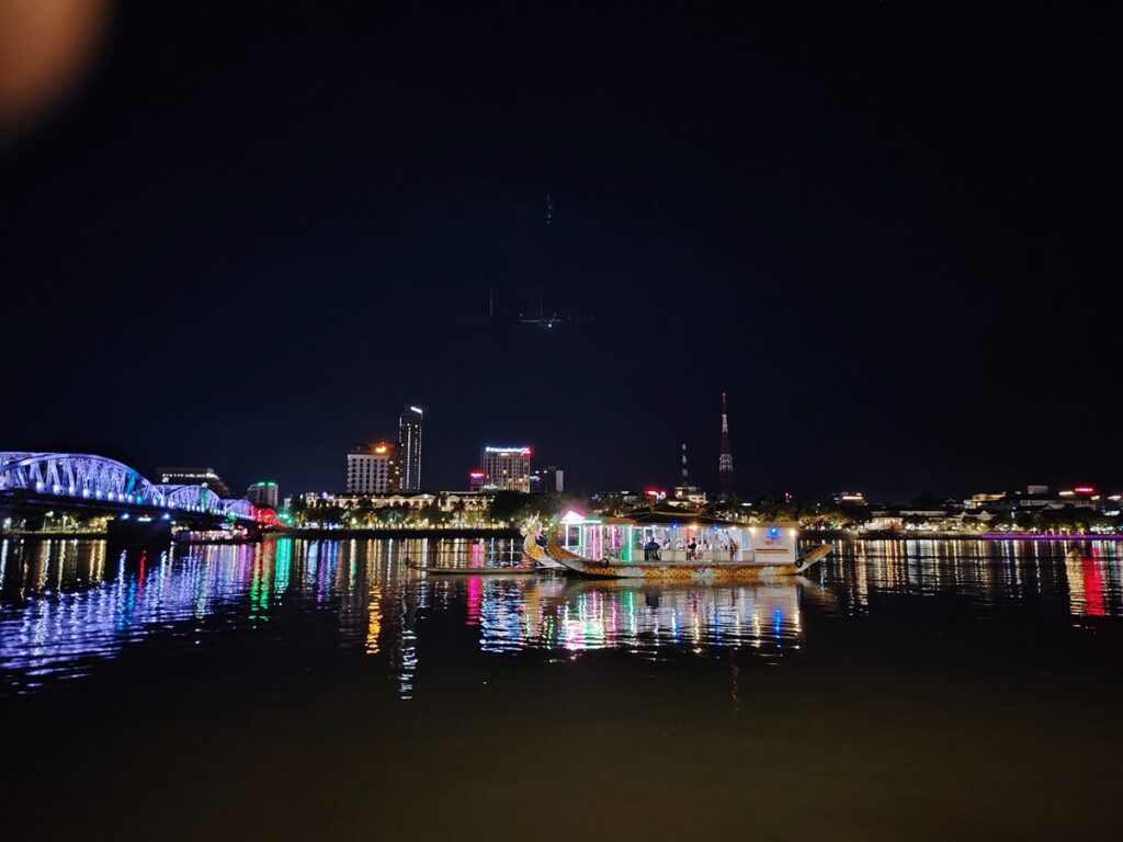 From riverfront restaurants in Hue City, enjoy the Perfume River at night with dragon boats and the shimmering Tràng Tiền Bridge.