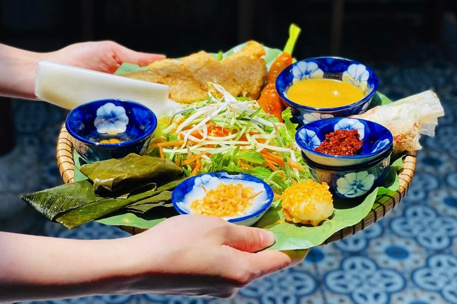 A variety of dishes from Madam Thu Restaurant's menu, showcasing traditional Hue cuisine, including Nem Lui, Banh Beo, and other local specialties.