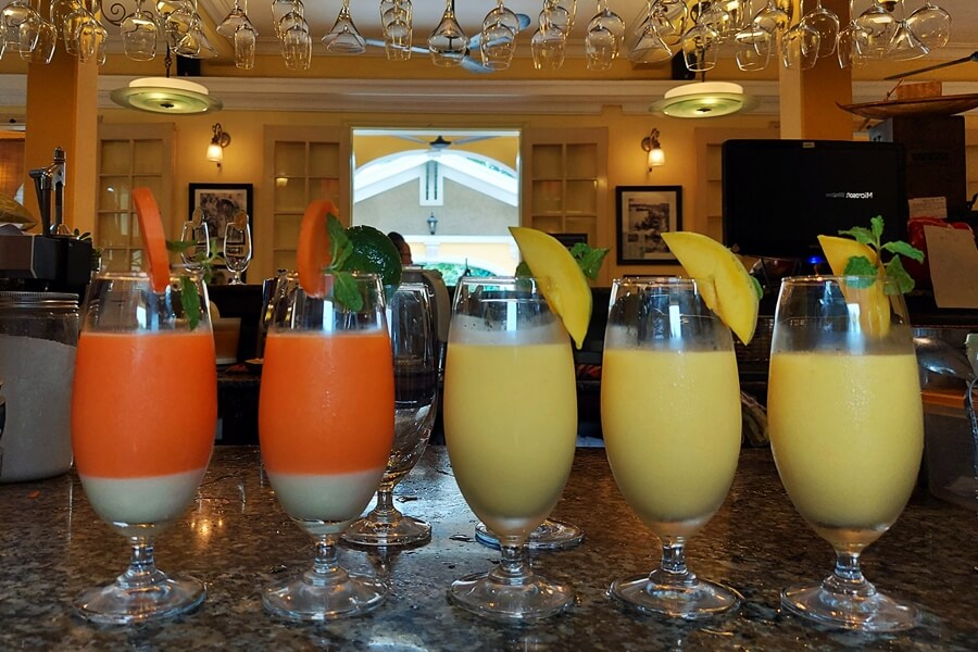 Colorful fruit shakes in yellow, red, and orange glasses