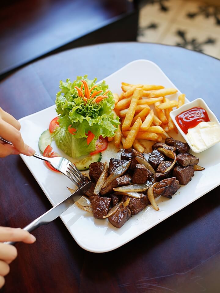 Stir-fried beef cubes with French fries on a plate