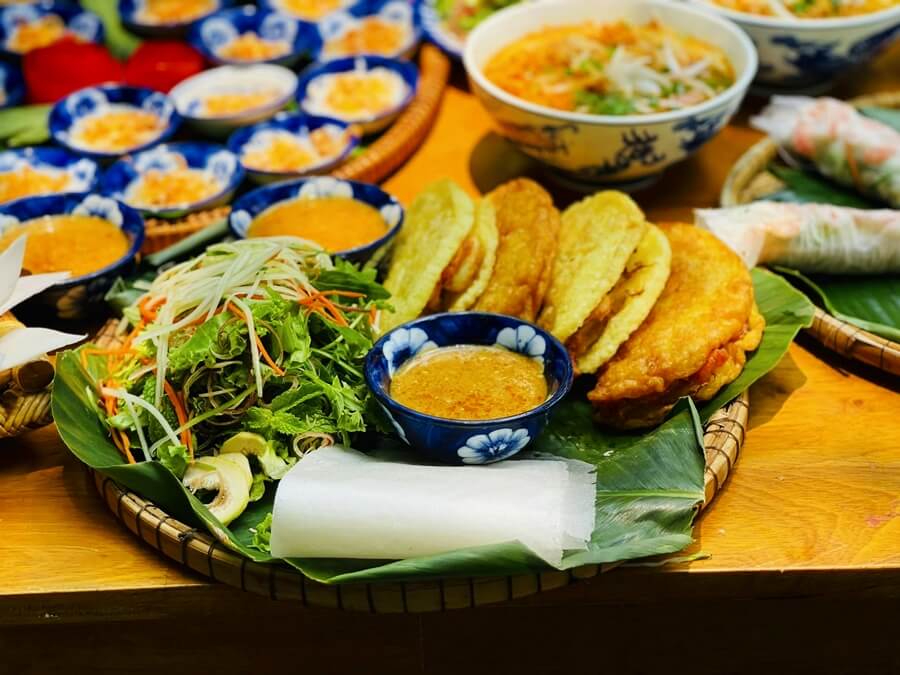 Hue Pancake (Bánh Khoái) at Madam Thu Restaurant with golden, crispy pancakes filled with shrimp and meat, served with a rich dipping sauce.