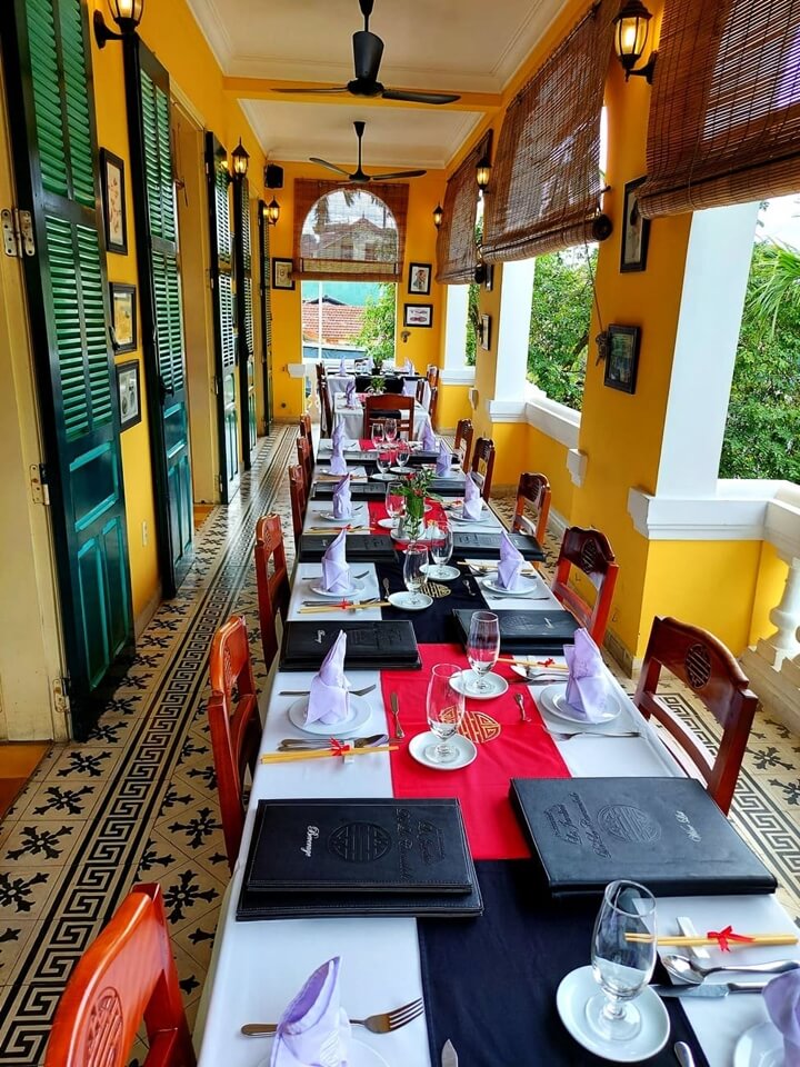 A row of tables set with cutlery on the second-floor balcony of the restaurant