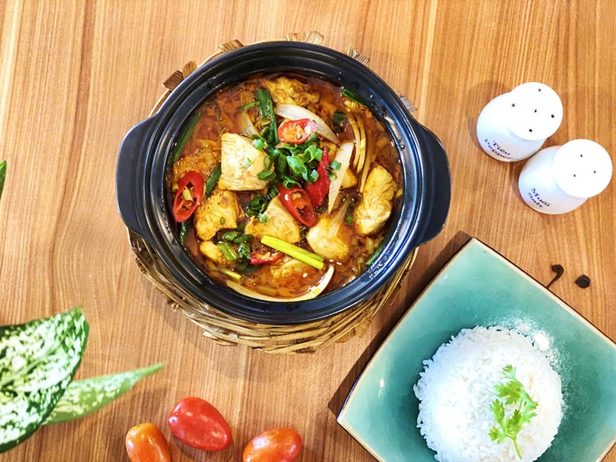ietnamese clay pot lemongrass chili chicken served with steamed white rice on a green ceramic plate at Spice Viet Hue
