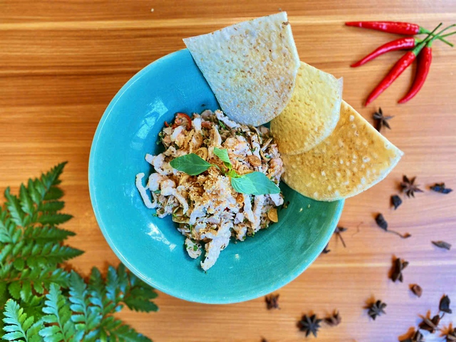 Hue-style fig salad mixed with shrimp, minced pork, peanuts, and fresh herbs, served with crispy rice crackers at Spice Viet Hue