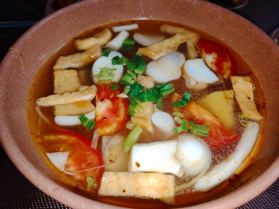 Light yellow sour vegetable and mushroom soup with tofu and lotus root, a refreshing vegetarian dish from Hue.