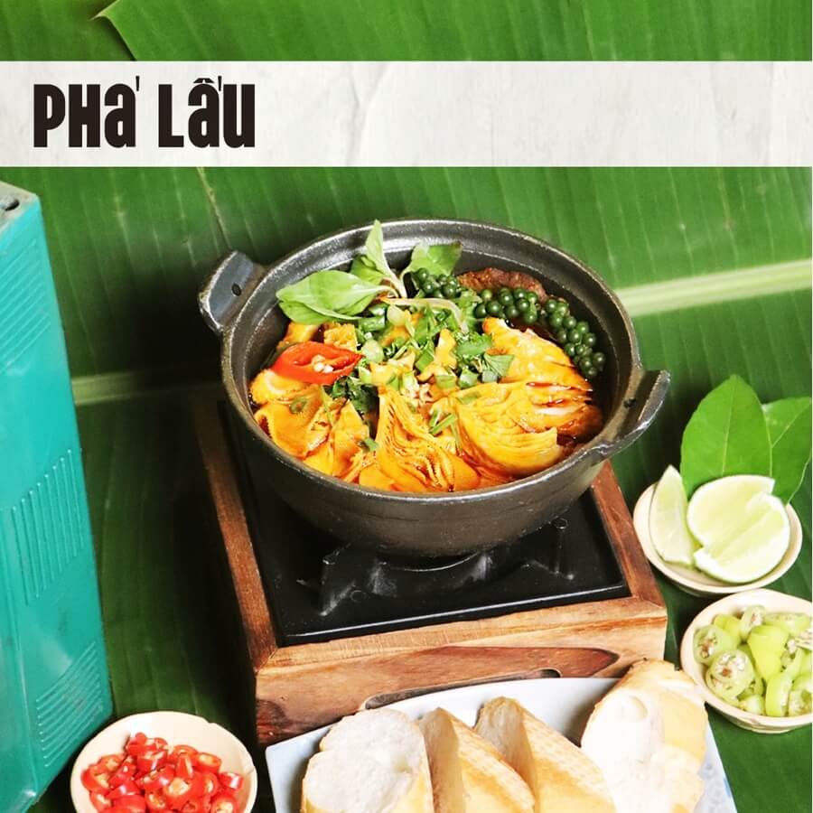 Flavorful Vietnamese Offal Stew (Phá Lấu) in a rich orange broth, served with fresh baguettes and green peppercorns at DMZ Bar Hue.