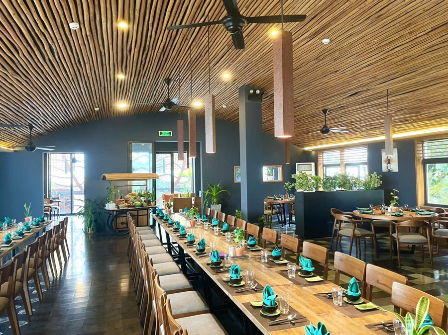 Tables arrranged well with dishes and eating tools in a spacious area inside the restaurant