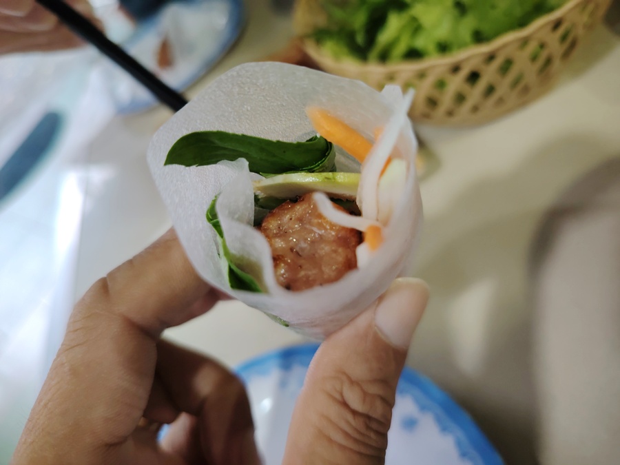 Nem lui served with fresh herbs, pickled vegetables, fig slices, wrapped in rice paper